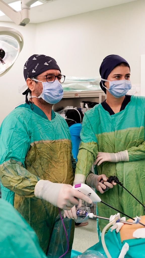 Medical professionals performing a laparoscopic surgery in a hospital operating room.